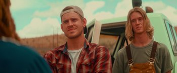 Movie still from “End of the Road” (2022), directed by Millicent Shelton – A man wearing a hat sitting next to a van; Close Up shot, Low angle
