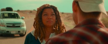 Movie still from “End of the Road” (2022), directed by Millicent Shelton – A woman with dreads standing next to a man; Close Up shot, Over the shoulder angle