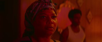 Movie still from “End of the Road” (2022), directed by Millicent Shelton – A person wearing a headscarf; Close Up shot, Over the shoulder angle