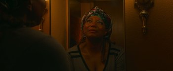 Movie still from “End of the Road” (2022), directed by Millicent Shelton – A woman wearing a head scarf looking up at the ceiling; Close Up shot, Over the shoulder angle