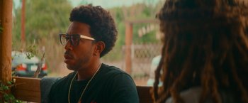 Movie still from “End of the Road” (2022), directed by Millicent Shelton – A man sitting next to a woman with dreadlocks; Close Up shot, Over the shoulder angle