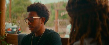 Movie still from “End of the Road” (2022), directed by Millicent Shelton – A man sitting next to a woman in a chair; Close Up shot, Over the shoulder angle