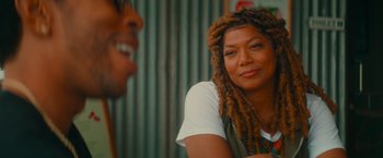 Movie still from “End of the Road” (2022), directed by Millicent Shelton – A woman with dreads sitting next to a man; Close Up shot, Over the shoulder angle