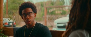 Movie still from “End of the Road” (2022), directed by Millicent Shelton – A person sitting on a bench; Close Up shot, Over the shoulder angle