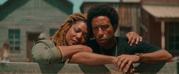 Movie still from “End of the Road” (2022), directed by Millicent Shelton – A man and a woman sitting next to each other on a bench; Close Up shot, Low angle