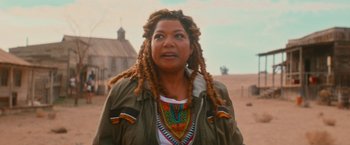 Movie still from “End of the Road” (2022), directed by Millicent Shelton – A woman with dreads standing in the desert; Close Up shot, Over the shoulder angle