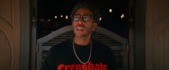 Movie still from “End of the Road” (2022), directed by Millicent Shelton – A man in a black shirt and glasses is looking at the camera; Close Up shot, Low angle