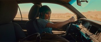 Movie still from “End of the Road” (2022), directed by Millicent Shelton – A woman sitting in the drivers seat of a car; Medium shot, Over the shoulder angle
