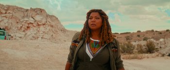 Movie still from “End of the Road” (2022), directed by Millicent Shelton – A woman with dreads standing in the desert; Medium shot, Low angle