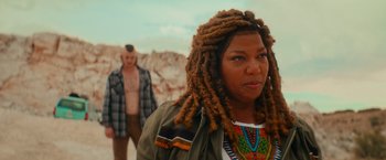 Movie still from “End of the Road” (2022), directed by Millicent Shelton – A man and a woman standing next to each other in front of rocks; Close Up shot, Over the shoulder angle