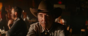 Movie still from “End of the Road” (2022), directed by Millicent Shelton – A man wearing a cowboy hat and a neck tie; Close Up shot, Low angle