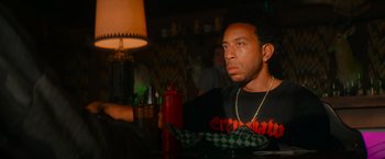 Movie still from “End of the Road” (2022), directed by Millicent Shelton – A man sitting at a table in front of a lamp; Close Up shot, Over the shoulder angle