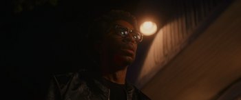 Movie still from “End of the Road” (2022), directed by Millicent Shelton – A man wearing glasses looking up at the ceiling; Close Up shot, Low angle