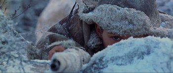 Movie still from “Enemy at the Gates” (2001), directed by Jean-Jacques Annaud – A young child hiding under a blanket in the snow; Close Up shot, Over the shoulder angle