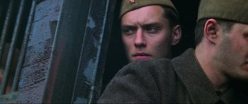 Movie still from “Enemy at the Gates” (2001), directed by Jean-Jacques Annaud – A man in a military uniform looking at the camera; Close Up shot, Low angle