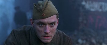 Movie still from “Enemy at the Gates” (2001), directed by Jean-Jacques Annaud – A man wearing a military uniform with a star on his hat; Close Up shot, Low angle