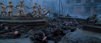 Movie still from “Enemy at the Gates” (2001), directed by Jean-Jacques Annaud – A group of men laying on the ground in the rain; Wide shot, High angle