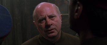 Movie still from “Enemy at the Gates” (2001), directed by Jean-Jacques Annaud – An older man is looking at the camera; Close Up shot, Over the shoulder angle