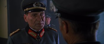 Movie still from “Enemy at the Gates” (2001), directed by Jean-Jacques Annaud – A man in a military uniform is talking to another man in a uniform; Close Up shot, Over the shoulder angle