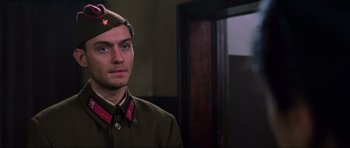 Movie still from “Enemy at the Gates” (2001), directed by Jean-Jacques Annaud – A man in a military uniform standing next to a door; Close Up shot, Low angle