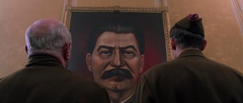 Movie still from “Enemy at the Gates” (2001), directed by Jean-Jacques Annaud – A painting of a man with a mustache and a beard; Close Up shot, Low angle