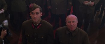 Movie still from “Enemy at the Gates” (2001), directed by Jean-Jacques Annaud – Two men in military uniforms posing for a picture; Medium shot, Low angle
