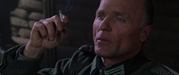 Movie still from “Enemy at the Gates” (2001), directed by Jean-Jacques Annaud – An older man smoking a cigarette while wearing a uniform; Close Up shot, Low angle