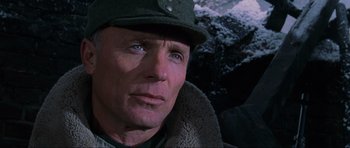 Movie still from “Enemy at the Gates” (2001), directed by Jean-Jacques Annaud – A person wearing a hat; Close Up shot, Over the shoulder angle