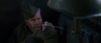 Movie still from “Enemy at the Gates” (2001), directed by Jean-Jacques Annaud – A man holding a metal rod in his mouth; Close Up shot, Overhead angle