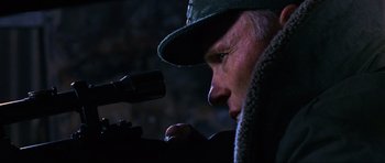 Movie still from “Enemy at the Gates” (2001), directed by Jean-Jacques Annaud – A person wearing a hat looking through a telescope; Close Up shot, Low angle