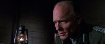 Movie still from “Enemy at the Gates” (2001), directed by Jean-Jacques Annaud – An older man with a goatee looking to his left; Close Up shot, Low angle