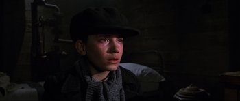 Movie still from “Enemy at the Gates” (2001), directed by Jean-Jacques Annaud – A young boy wearing a hat and a scarf; Close Up shot, High angle