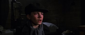 Movie still from “Enemy at the Gates” (2001), directed by Jean-Jacques Annaud – A young boy wearing a hat and a scarf crying; Close Up shot, High angle