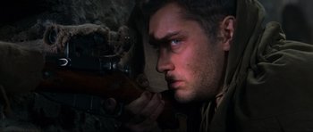 Movie still from “Enemy at the Gates” (2001), directed by Jean-Jacques Annaud – A person holding a rifle; Close Up shot, Low angle