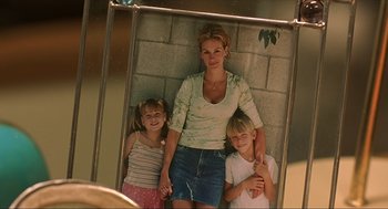 Movie still from “Erin Brockovich” (2000), directed by Steven Soderbergh – A woman and two children posing for a picture; Medium shot, High angle
