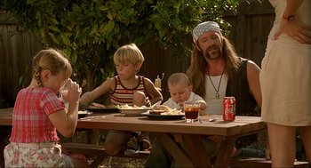 Movie still from “Erin Brockovich” (2000), directed by Steven Soderbergh – A group of people sitting at a picnic table eating food; Medium shot, Over the shoulder angle
