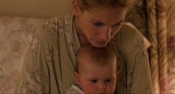 Movie still from “Erin Brockovich” (2000), directed by Steven Soderbergh – A woman is holding a baby in her arms; Close Up shot, High angle