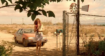 Movie still from “Erin Brockovich” (2000), directed by Steven Soderbergh – A woman walking in the dirt near a windmill; Wide shot, Low angle