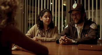 Movie still from “Erin Brockovich” (2000), directed by Steven Soderbergh – Two people sitting at a wooden table in front of each other; Medium shot, Over the shoulder angle