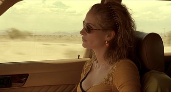 Movie still from “Erin Brockovich” (2000), directed by Steven Soderbergh – A woman sitting in the back seat of a car looking out the window; Close Up shot, Over the shoulder angle