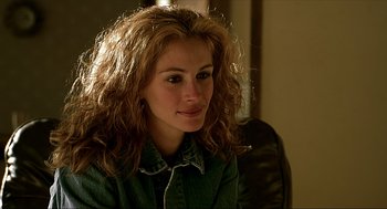 Movie still from “Erin Brockovich” (2000), directed by Steven Soderbergh – A person sitting in a room; Close Up shot, Over the shoulder angle