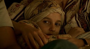 Movie still from “Erin Brockovich” (2000), directed by Steven Soderbergh – A young boy wearing a head scarf is looking at the camera; Close Up shot, Over the shoulder angle