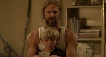 Movie still from “Erin Brockovich” (2000), directed by Steven Soderbergh – A man and a boy are looking at a book; Close Up shot, Low angle