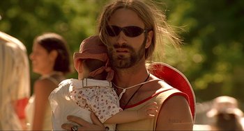Movie still from “Erin Brockovich” (2000), directed by Steven Soderbergh – A man holding a baby while wearing sunglasses; Close Up shot, Low angle