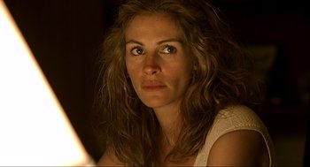 Movie still from “Erin Brockovich” (2000), directed by Steven Soderbergh – A beautiful woman with long brown curly hair looking at the camera; Close Up shot, Low angle