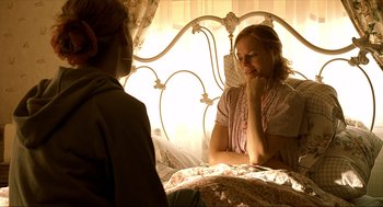 Movie still from “Erin Brockovich” (2000), directed by Steven Soderbergh – A woman sitting on a bed talking to another woman; Medium shot, Over the shoulder angle