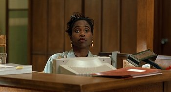 Movie still from “Erin Brockovich” (2000), directed by Steven Soderbergh – A person sitting at a desk in front of a computer; Close Up shot, Low angle