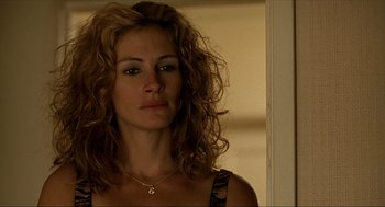 Movie still from “Erin Brockovich” (2000), directed by Steven Soderbergh – A person with curly hair wearing a necklace; Close Up shot, Over the shoulder angle