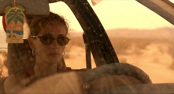 Movie still from “Erin Brockovich” (2000), directed by Steven Soderbergh – A woman wearing sunglasses looking out the window of an airplane; Close Up shot, Over the shoulder angle