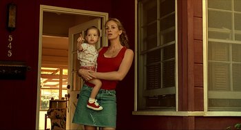 Movie still from “Erin Brockovich” (2000), directed by Steven Soderbergh – A woman holding a baby in her arms; Medium shot, Low angle